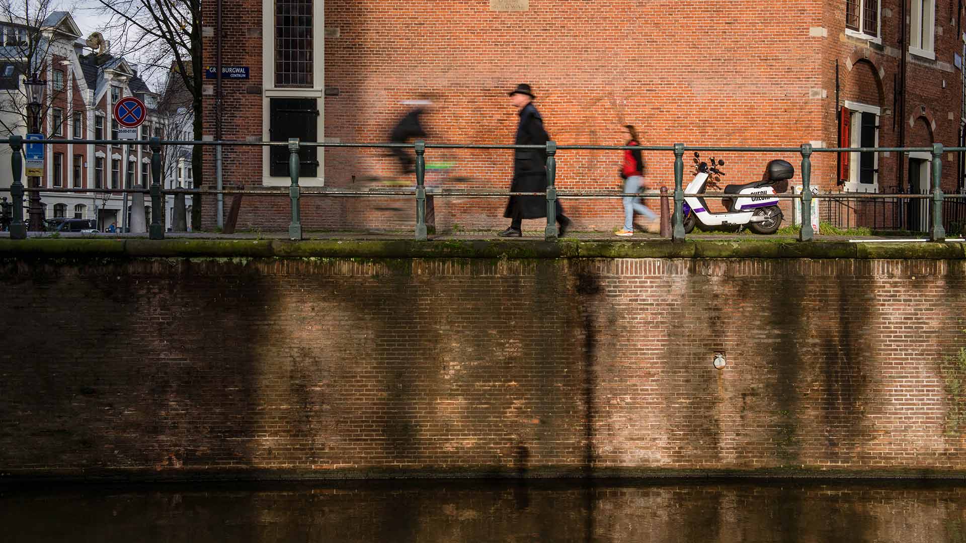 Wandelende mensen langs kade Amsterdam