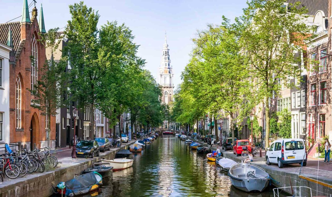 Gracht in Amsterdam met aan beide kanten grachtenpanden en uitzicht op de Westerkerk