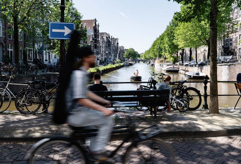 Fietser op kademuren in binnenstad Amsterdam