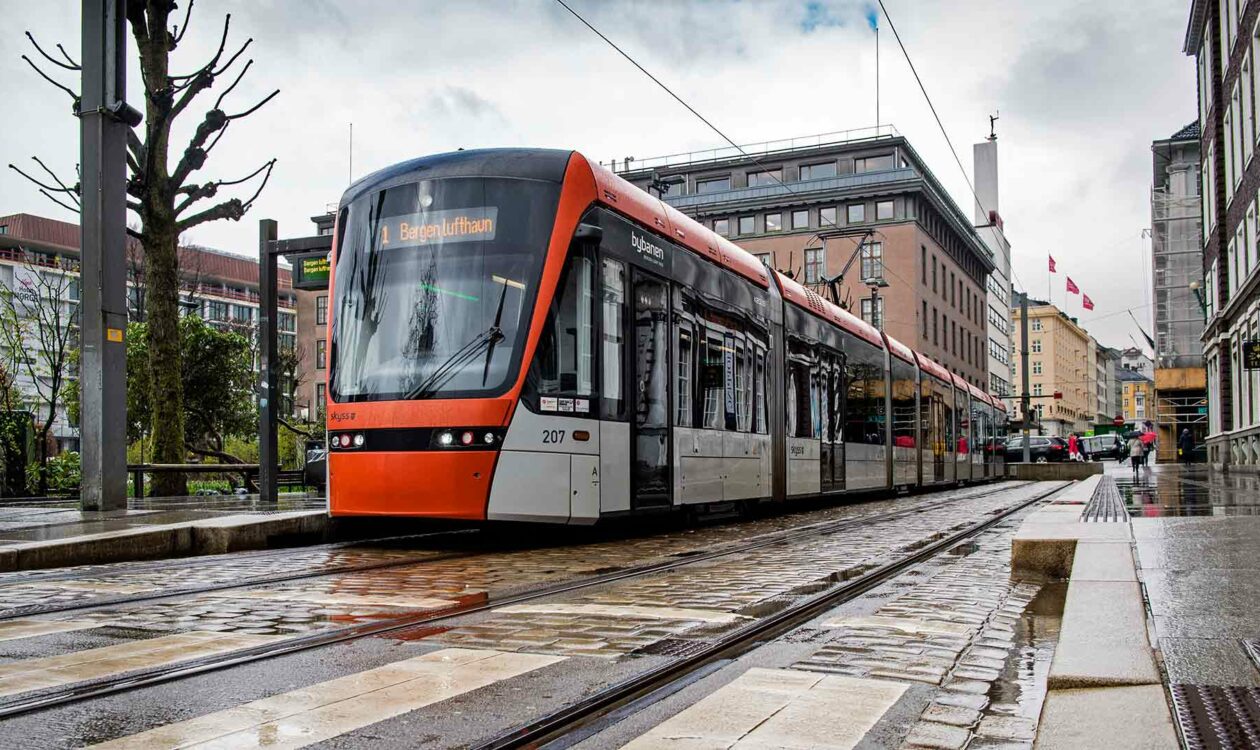 Bybanen Lightrail in natte straat met gebouwen