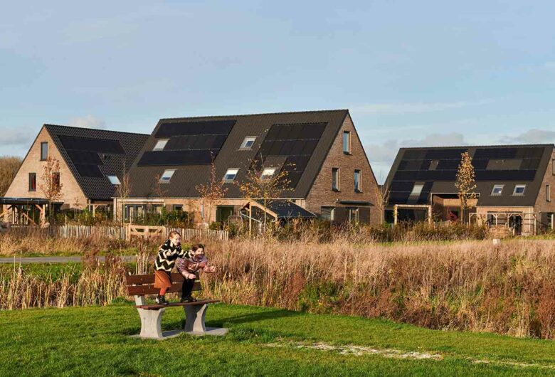 spelende kinderen in duurzame woonwijk met zonnepanelen op de huizen in Leeuwarden