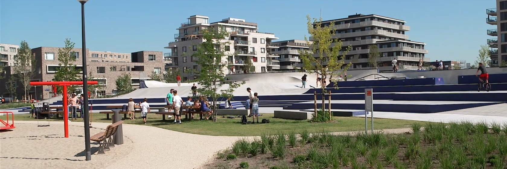 Parkachtige omgeving met skate faciliteiten tegen achtergrond appartementenblokken