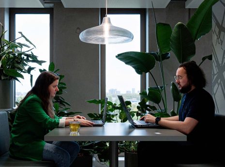 Twee mensen in gesprek aan tafel in kantooromgeving