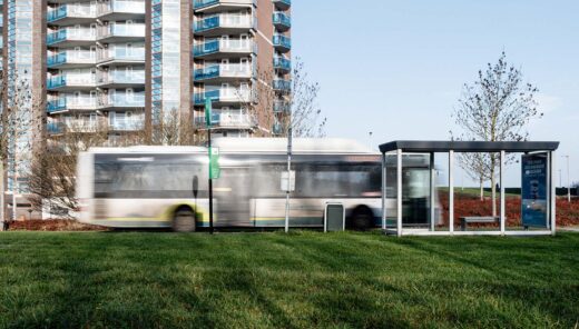 Bus met bushokje en flat op achtergrond