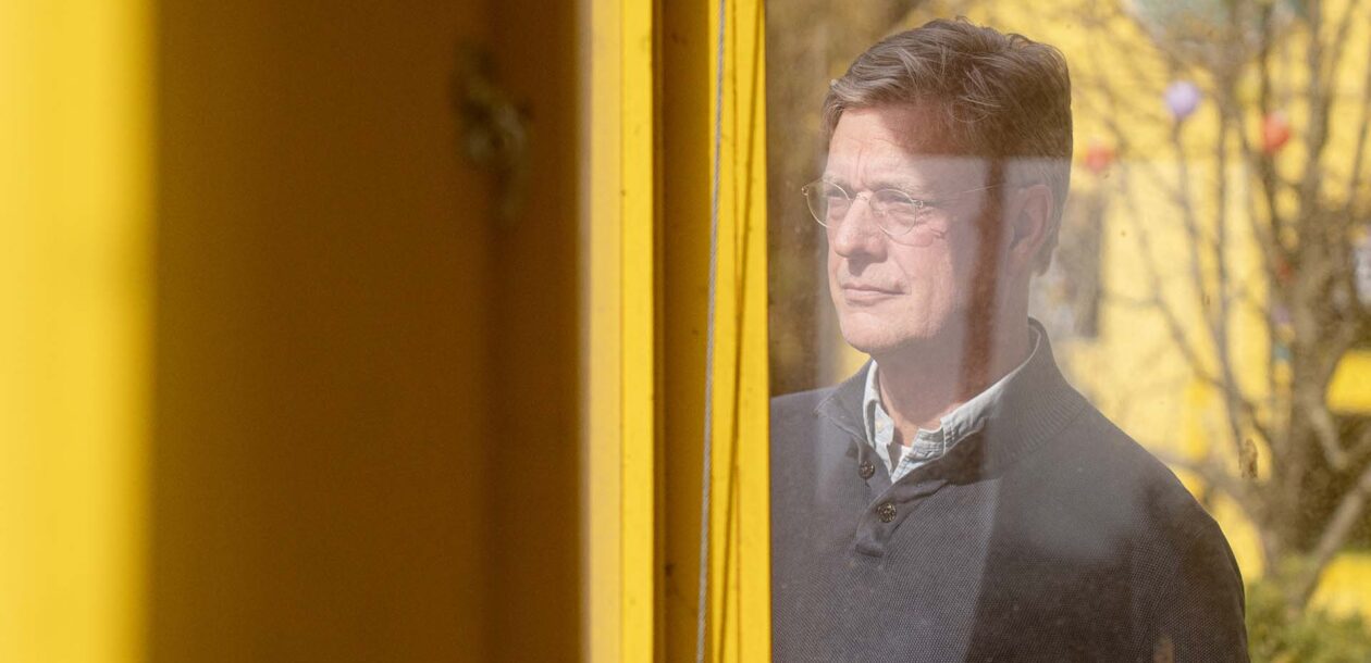 Foto van Eugene Grüter, CEO Sweco Nederland die achter glas kantoor naar buiten staat te kijken