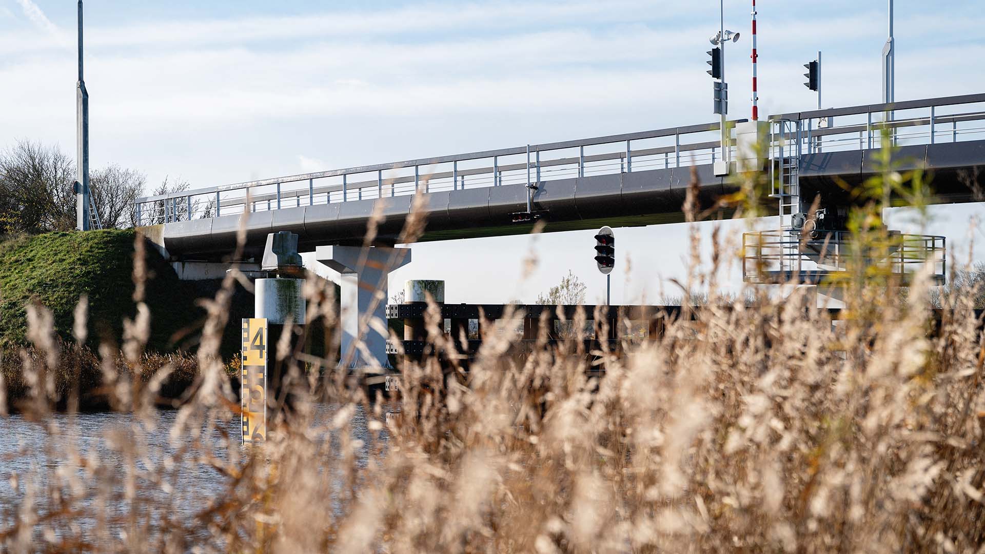 Fietsbrug gezien vanaf de rietkraag langs het water naar boven