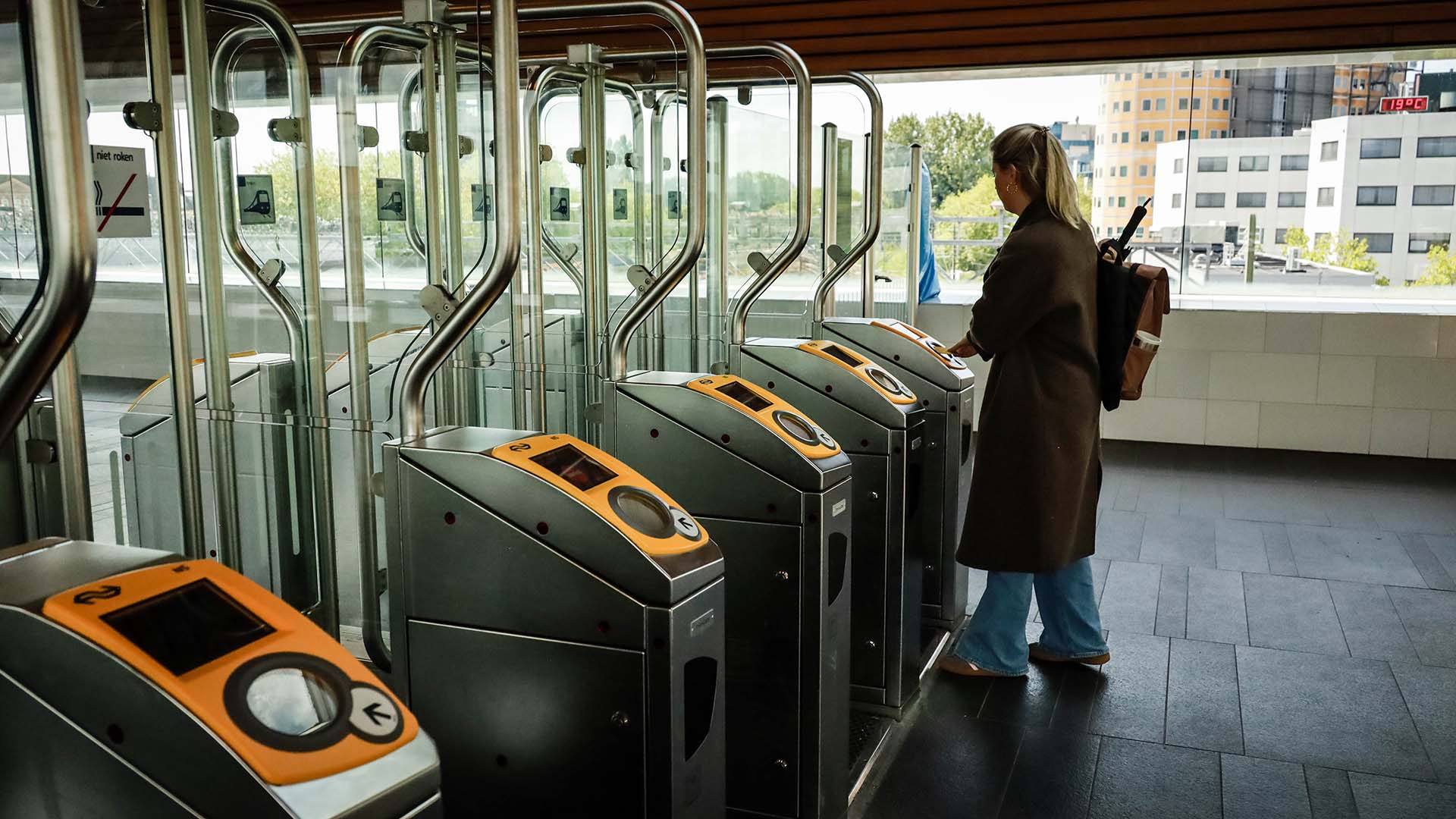 Blondharige vrouw bij incheckpoort tram- of metrostation
