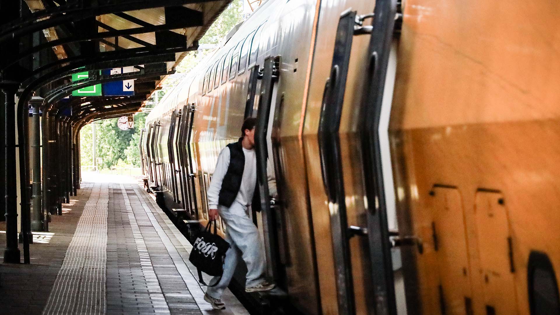 Persoon stap in open deuren trein op station