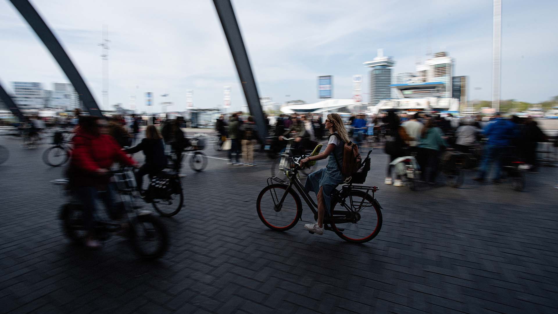 Fietsers op station met hoge gebouwen op achtergrond