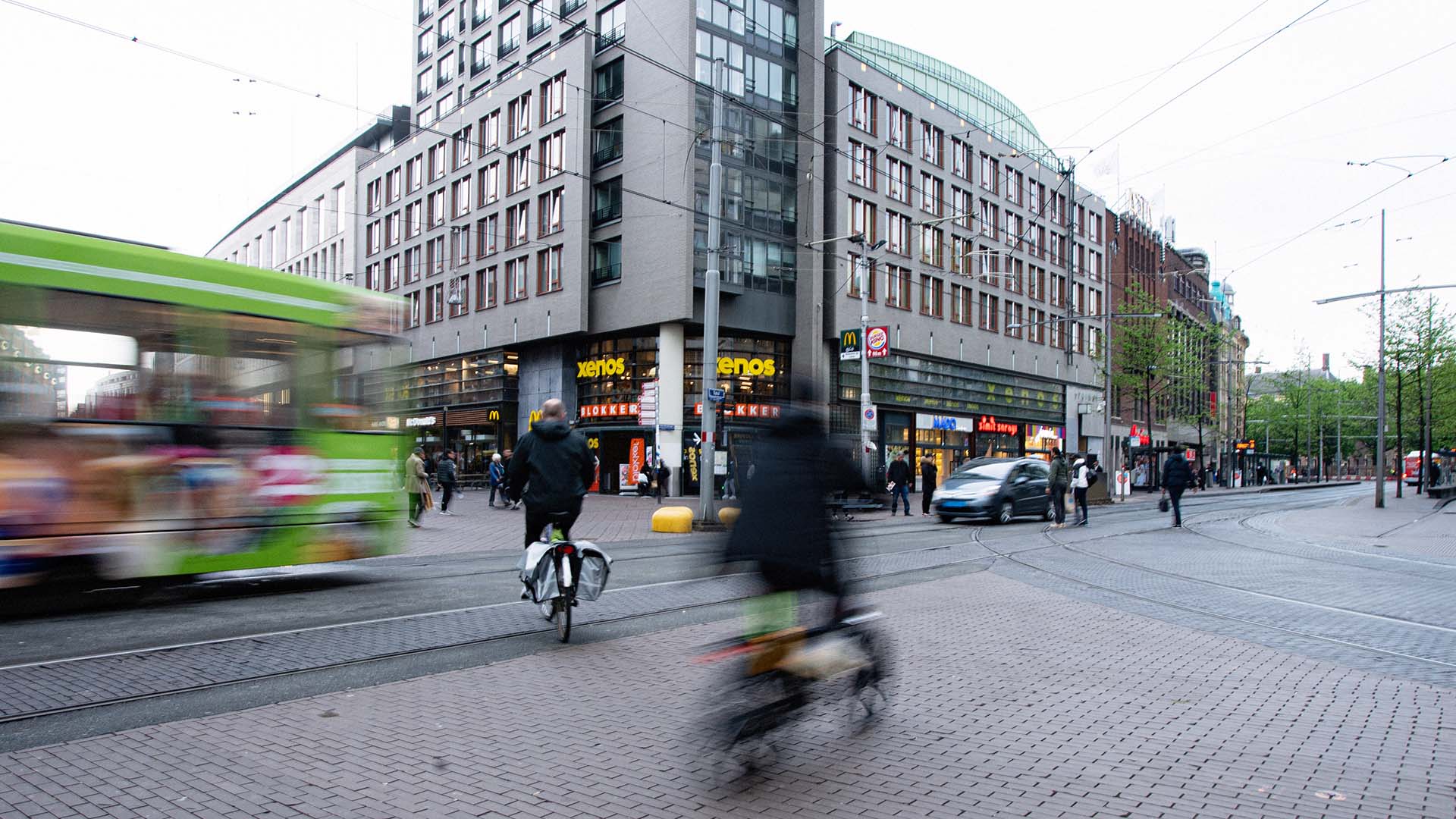 Druk verkeerkruispunt met fietsers, bus, auto in binnenstad.