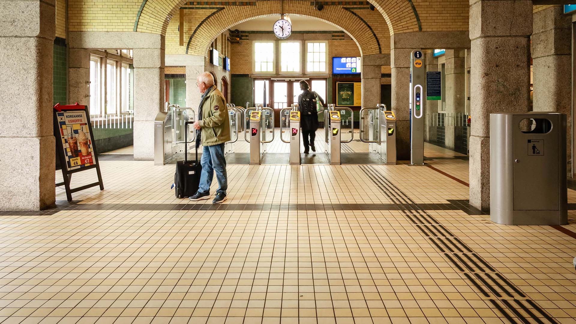 Binnenfoto station met passagiers en toegangspoortjes
