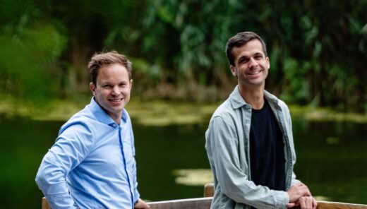 Twee blanke mannen bij een meertje in een groene omgeving