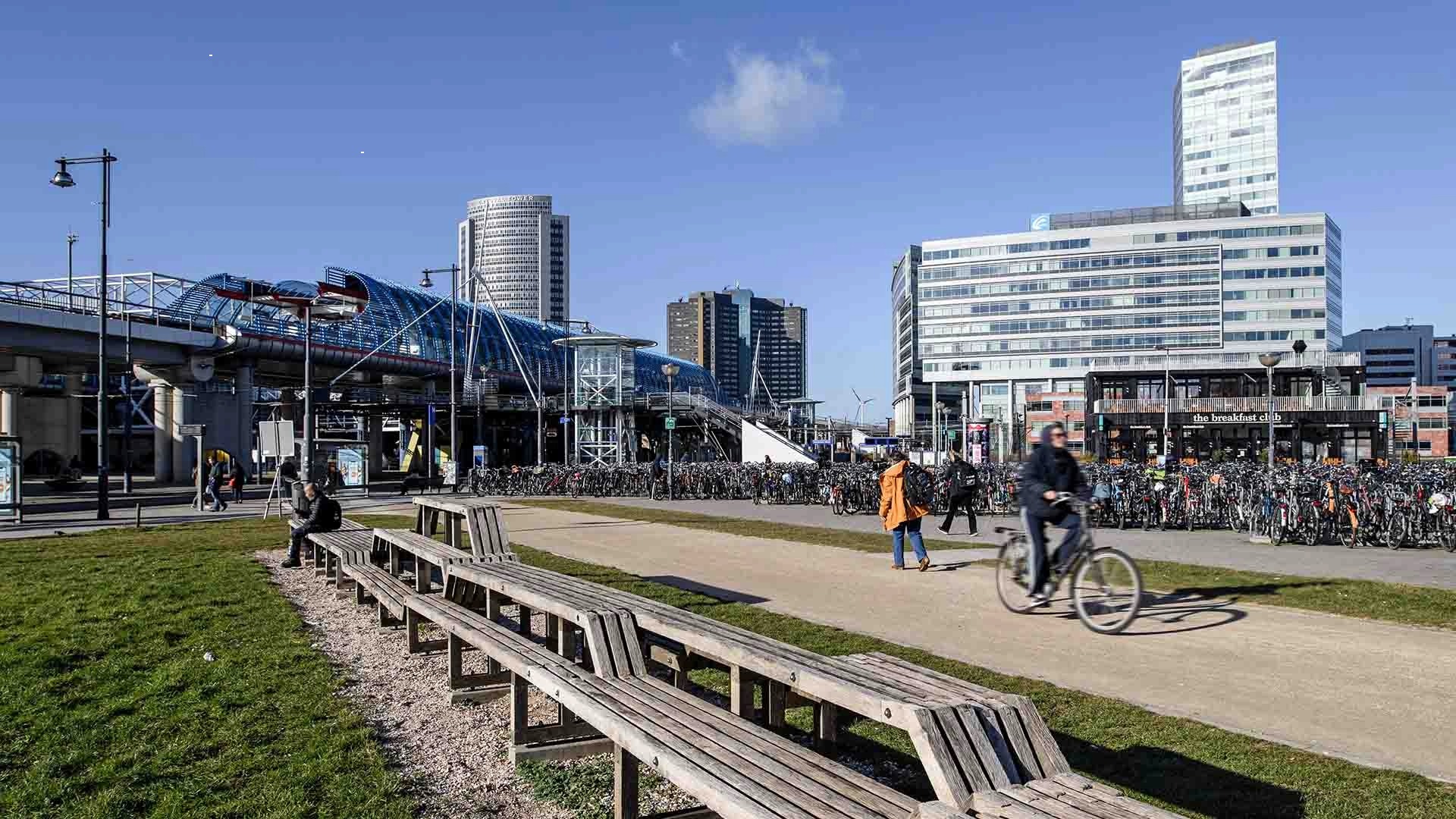 Fietsenstalling bij station in Amsterdam met voetgangers en fietsers