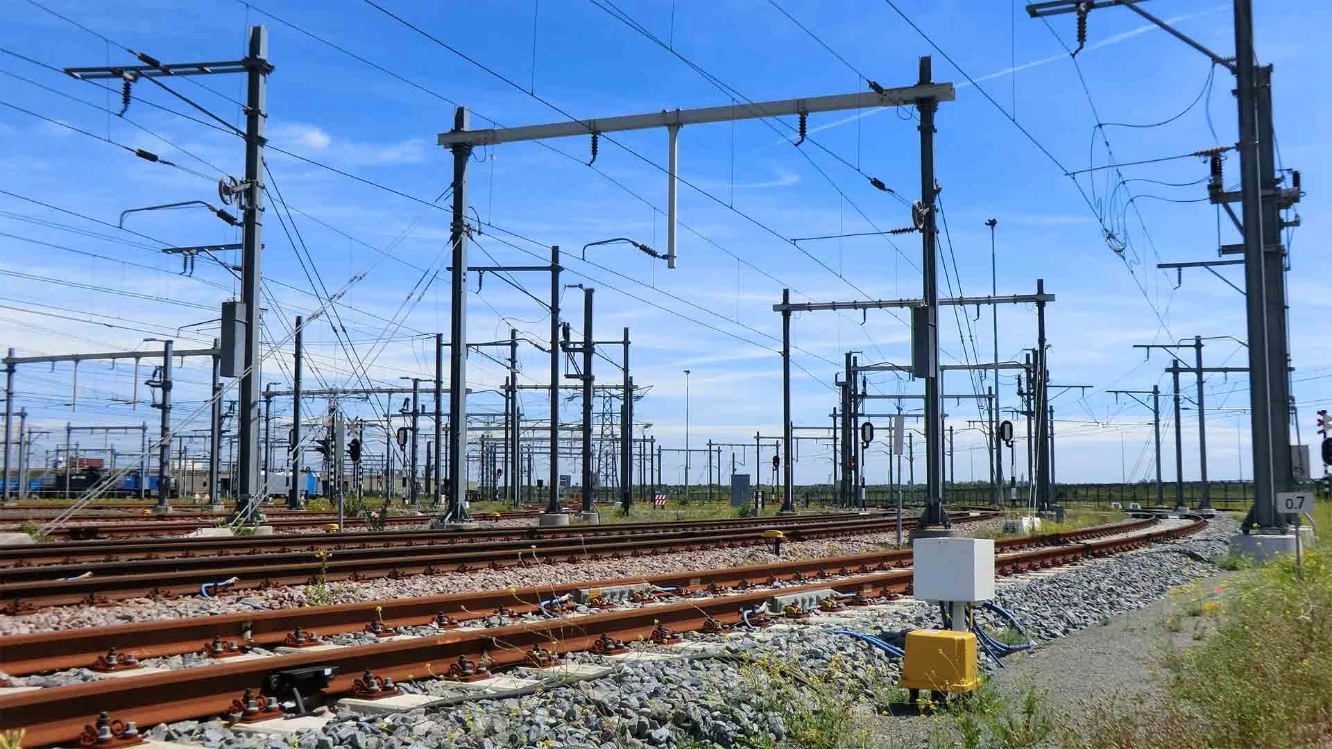 Meerder treinsporen die elkaar raken inclusief bovenleidingen.