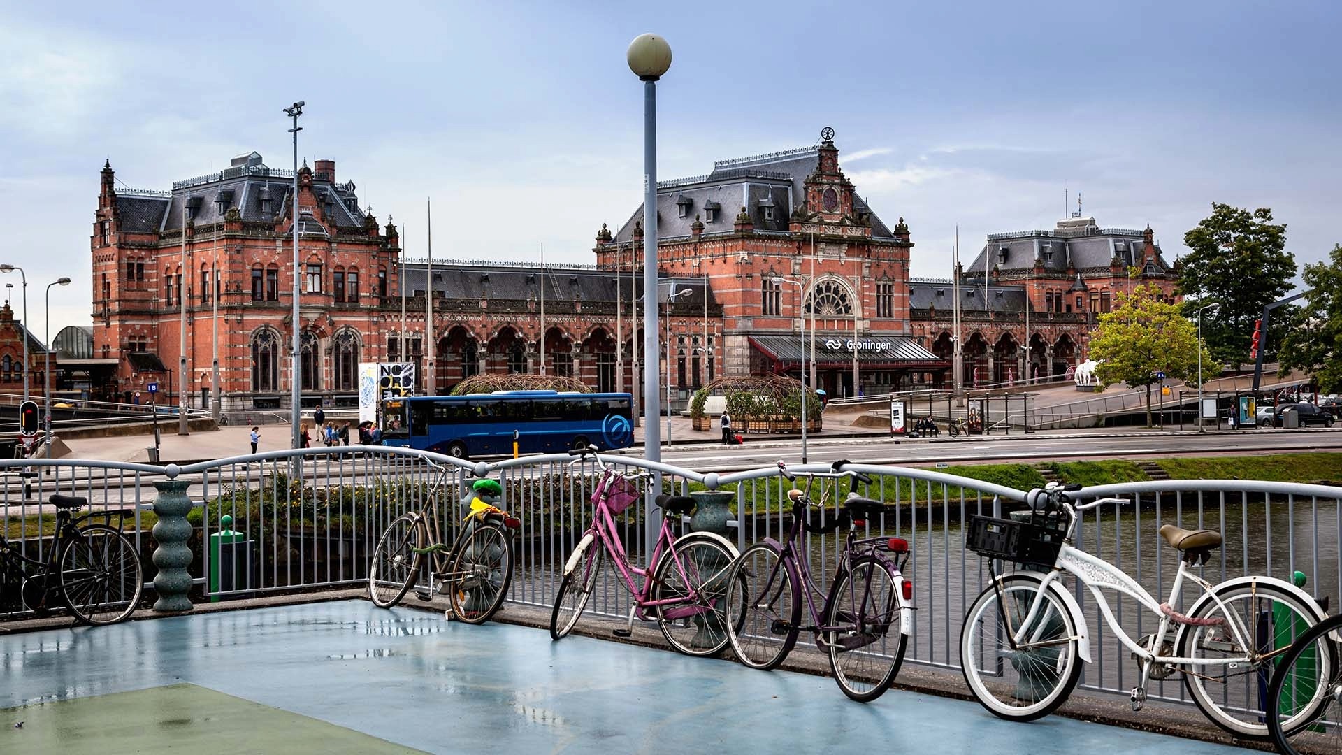 Momumentaal pand station Groningen met water en fietsen op voorgrond