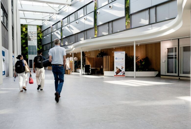 Bezoekers lopen door de lichte centrale hal van de campus van Boston Scientific