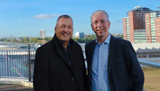 Twee mannen op zonnige dag met hoogbouw op achtergrond