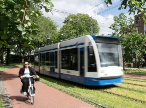 Tram in Amsterdam naast fietspad en groen