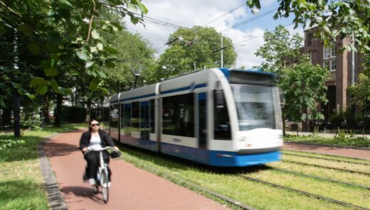 Tram in Amsterdam naast fietspad en groen