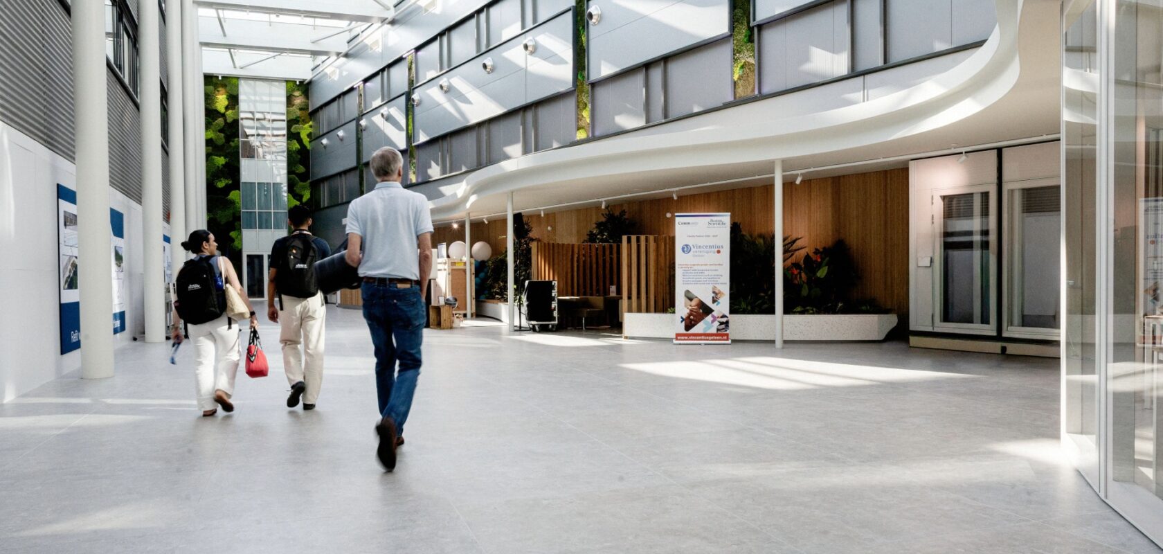 Bezoekers lopen door de lichte centrale hal van de campus van Boston Scientific.